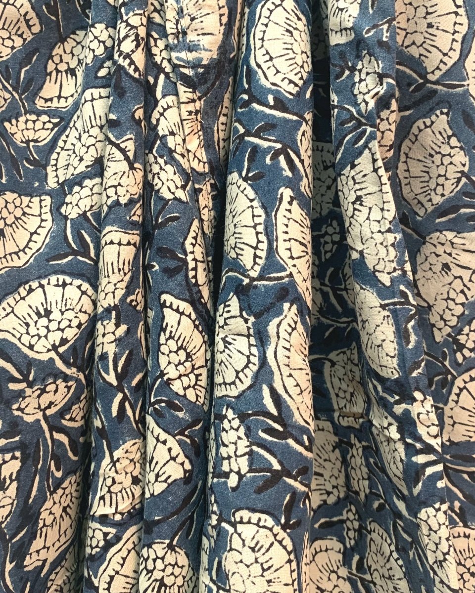 Closeup of the Oversized Scarf in Poppy. The scarf is blue with a cream poppy pattern printed on it.