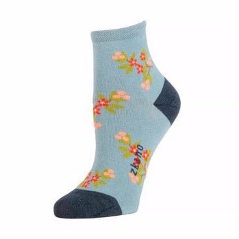 Light blue sock with pink, red and green floral pattern and the Zkano logo along the arch. The heel and toe are a navy blue. The Mae Anklet Sock in Lead is from Zkano and made in Alabama, USA.