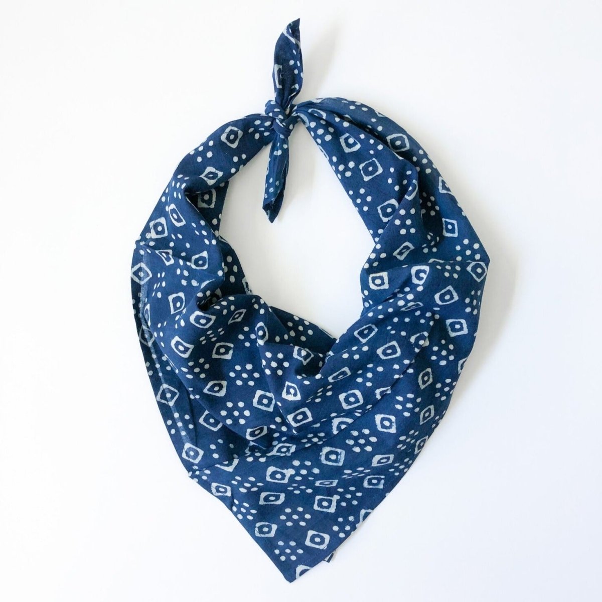 A blue and white patterned bandana, folded over and tied in a knot. Block printed by hand, the Billie Bandana from Maelu is designed in Portland, Oregon and handmade in India.