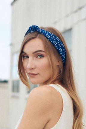 A woman looks over her shoulder with her hair pulled back in a bandana. The Billie Bandana from Maelu is designed in Portland, Oregon and handmade in India.