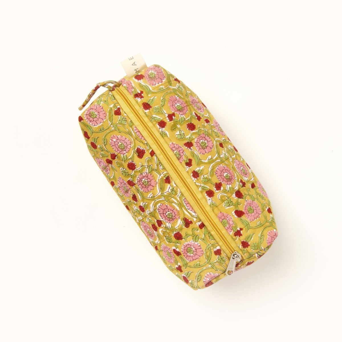 A yellow, pink, green and red floral patterned makeup bag. The Maya Makeup Bag from Maelu is designed in Portland, Oregon and printed in India.