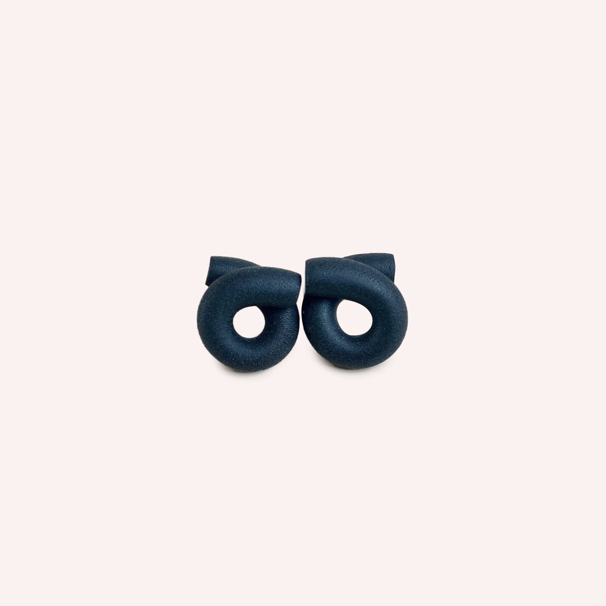 Polymer clay stud earrings in a loop formation and off-white color. The Medium Loop Earrings inCream are designed and handcrafted by Little Pieces Jewelry in Los Angeles, California.