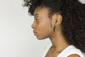 Striking, yet lightweight, mini Lié hoop earrings, pictured on the profile of a model with curly hair.