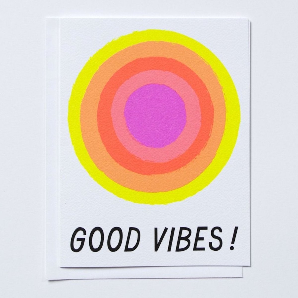 White card with circular layers of neon yellow, orange, pink and purple. Bottom of card reads: "GOOD VIBES!" in black text. Made with recycled paper by Banquet Atelier in Vancouver, British Columbia, Canada.