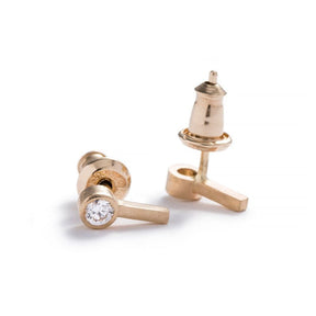 Tiny, ankh-shaped stud earrings of 14k yellow gold, topped with round, bezel-set white diamonds, and finished with 14k gold earring posts and ear nuts. Hand-crafted in Portland, Oregon.