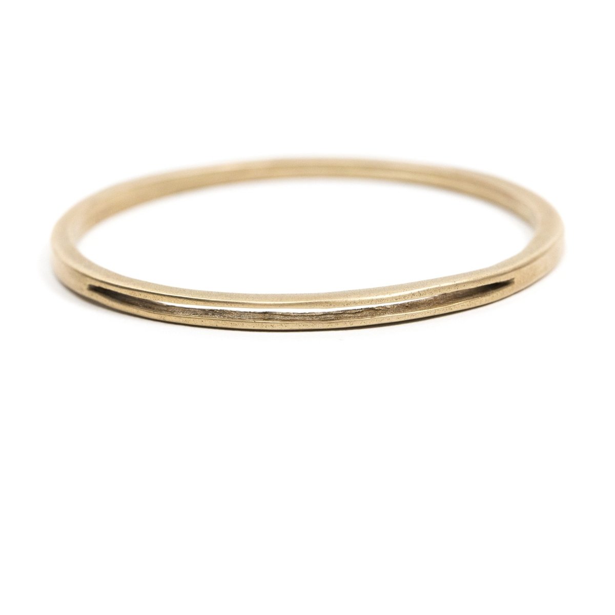 Sturdy, circular, cast-bronze bangle bracelet, featuring one long, slim, cutout slit in the metal. Hand-crafted in Portland, Oregon. 