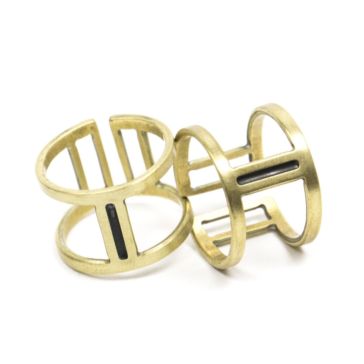 Two wide, adjustable brass rings with large, rectangular cutouts surrounding a slim, oxidized center piece. Hand-crafted in Portland, Oregon. 