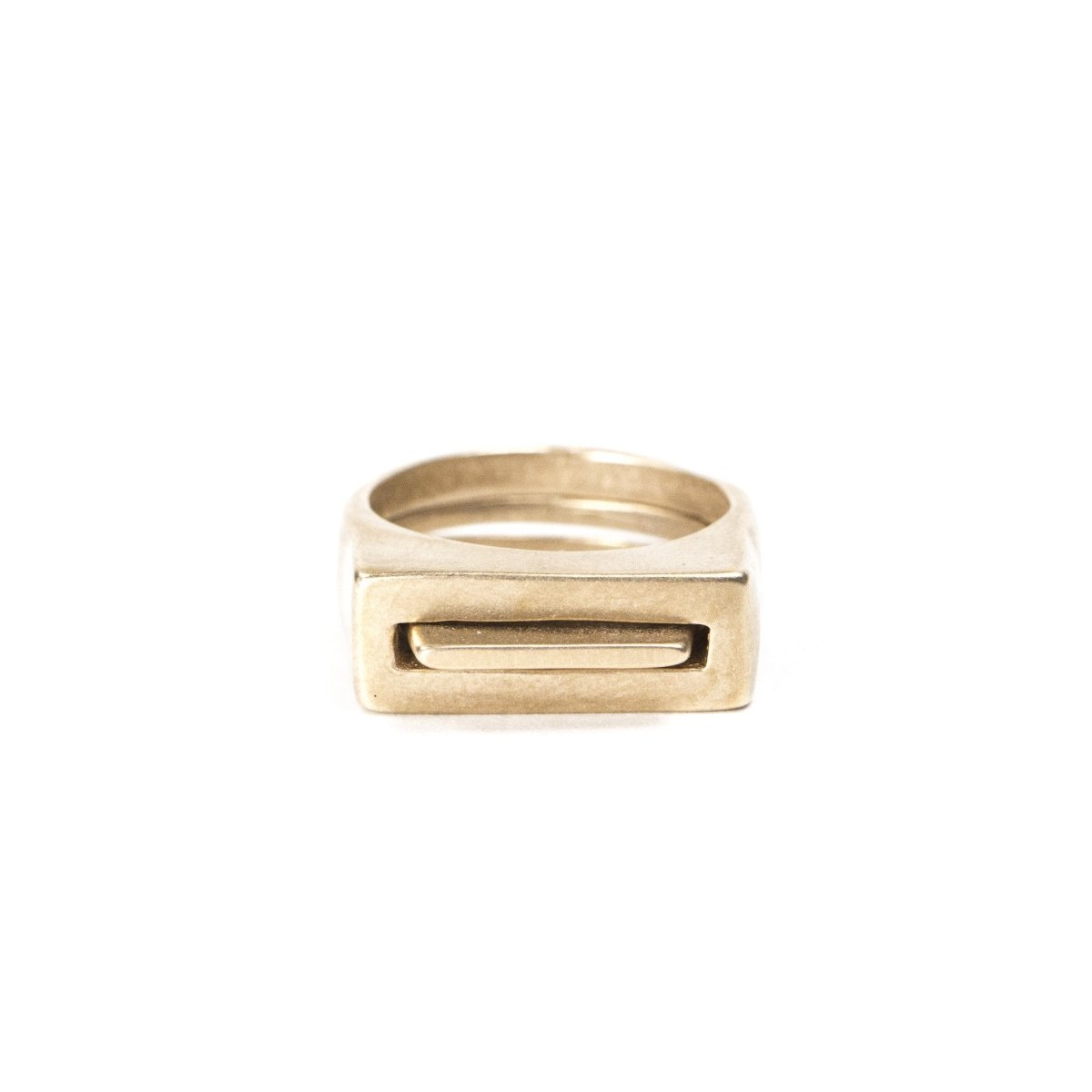 A pair of contemporary cast-bronze rings, featuring one thin ring with an elongated curve (Tuyo) fitted through a chunky ring with a rectangular cutout (Mía). Hand-crafted in Portland, Oregon. 