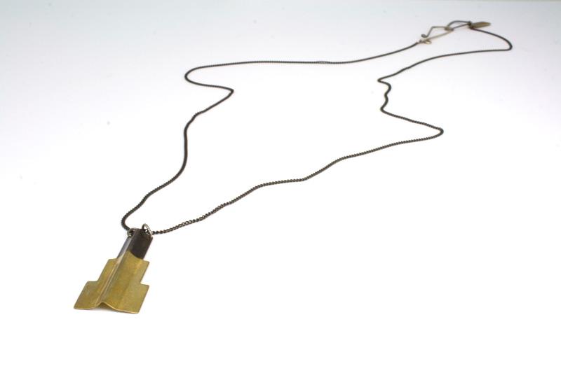 Picture of the jagged plateau necklace laying on a table.