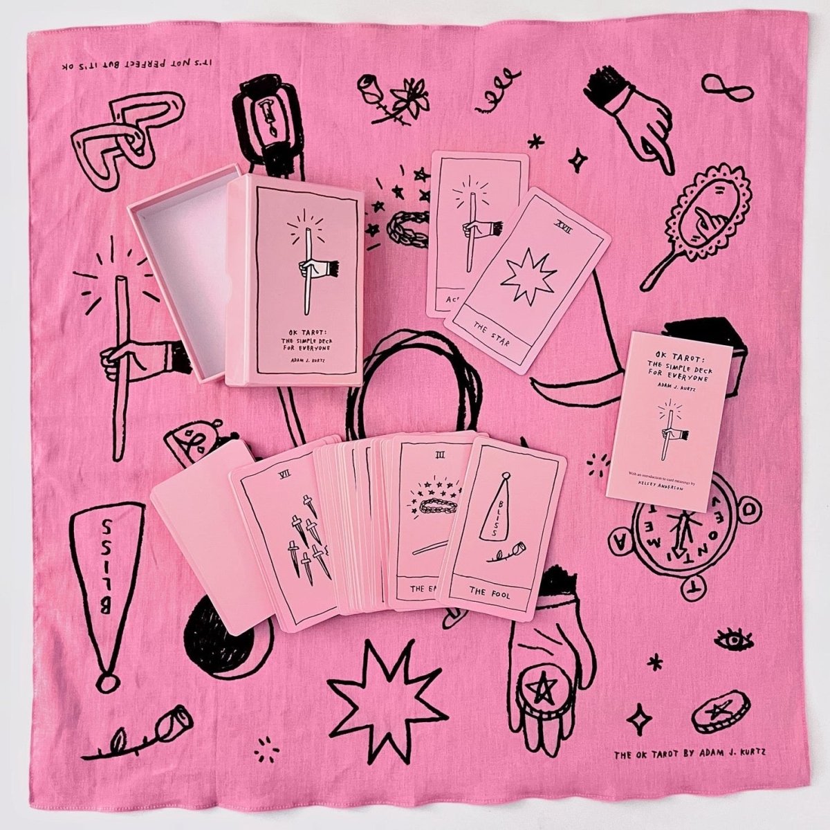 A pink background with a tarot deck and hand drawn illustrations. The Ok Tarot Deck is from Adam J. Kurtz.