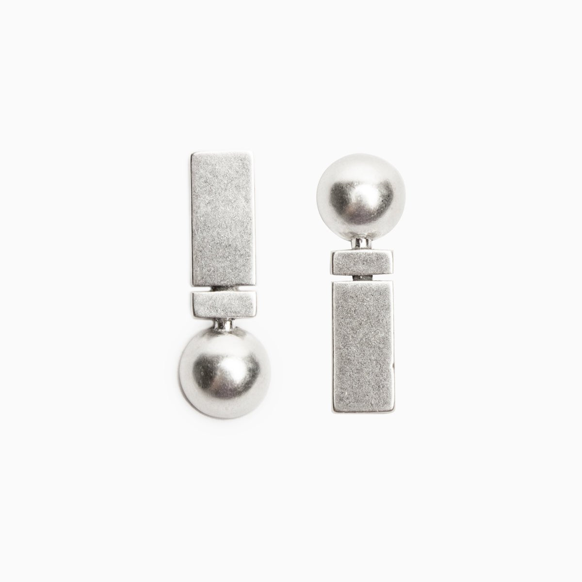 A sterling silver stud earring featuring opposing circular and rectangular shapes. The Oriri Earrings are designed and handcrafted in Portland, Oregon.