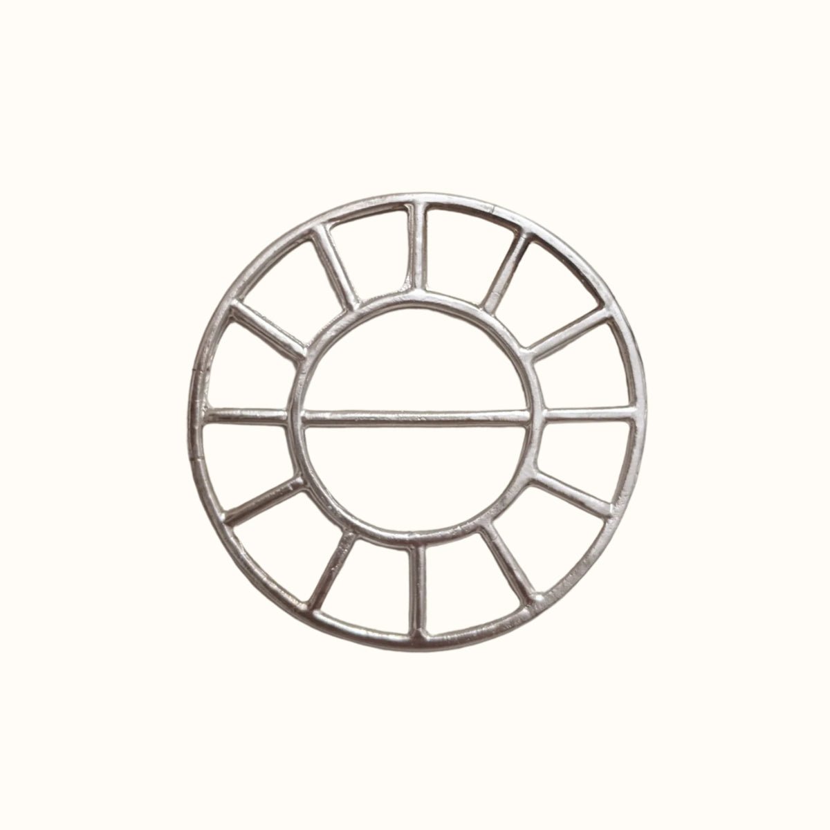 A circular brass scarf bolo. The Scarf Bolo is designed and handmade by Take Shape Studio in Berkeley, California.