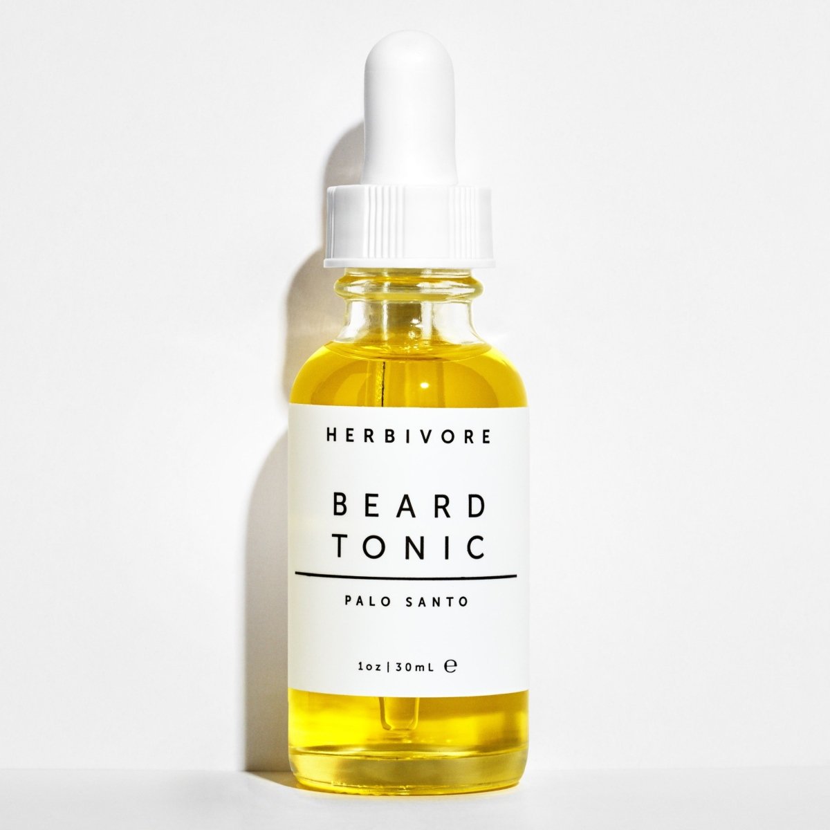 1 oz. glass bottle with dropper filled with Palo Santo beard tonic. Created by Herbivore Botanicals and made in Seattle, Washington. 