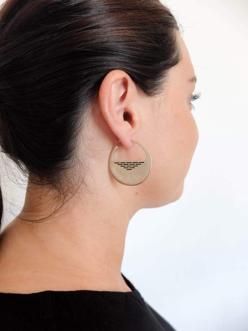 Bronze and black paint Portsmouth hoop earrings, pictured on the profile of a model wearing her hair in a ponytail.