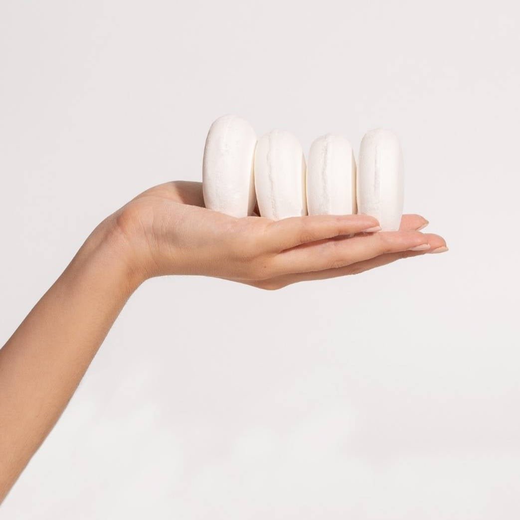 A model holds four shower steamer disks. The Aromatherapy Shower Steamers in Rescue are formulated by Klei Beauty and manufactured in New Jersey, USA.