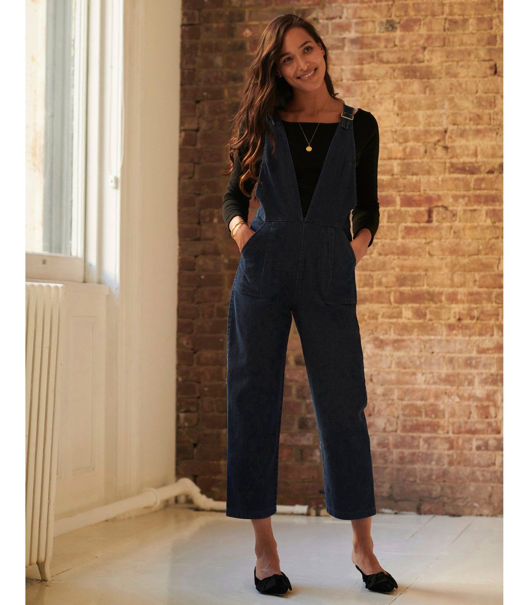 Model wears the Rhoda Coveralls in Indigo over a black long sleeved shirt. The Rhoda Coveralls in Indigo are designed by Loup and made in New York City, USA.