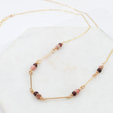 A string of smooth garnet and faceted pink rhodocrosite connected with gold-fill bars. Designed and handmade by Amy Olson in Portland, Oregon.