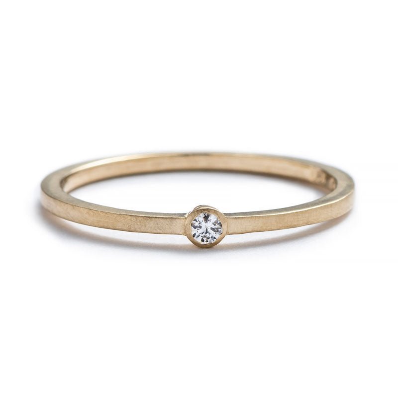 Thin, 14k yellow gold band with a matte finish, featuring a small, round, bezel-set white diamond. Hand-crafted in Portland, Oregon. 
