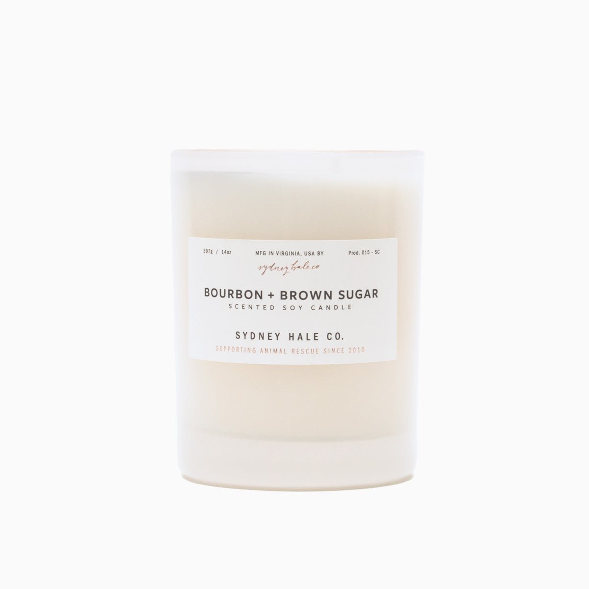 A cylindrical glass candle filled with a soy wax blend and two double cotton wicks. Label reads: "397g/14 oz. Manufactured in Virginia, USA by Sydney Hale Co. Bourbon + Brown Sugar scented soy candle. Sydney Hale Co. Supporting Animal rescue since 2010."