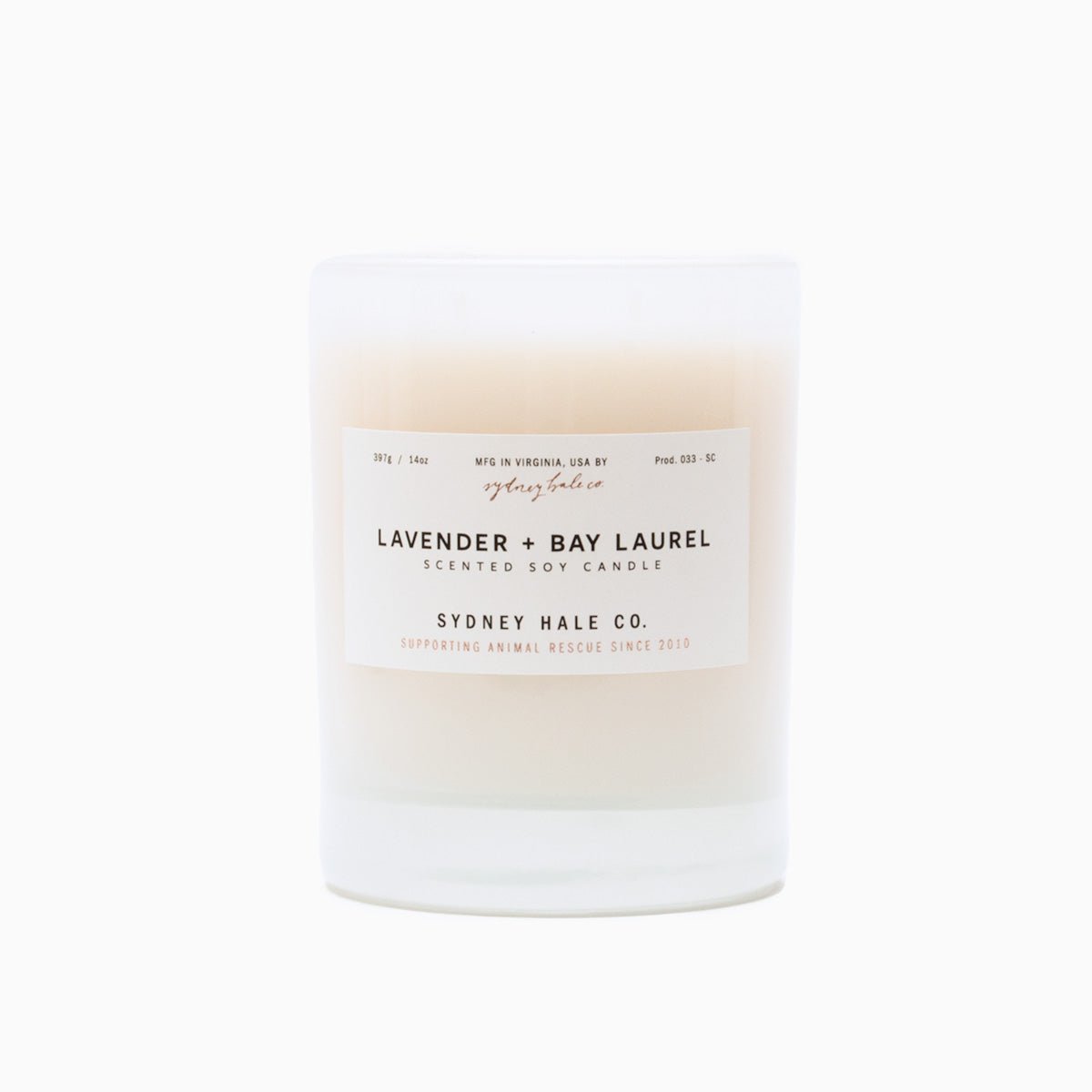  A cylindrical glass candle filled with a soy wax blend and two double cotton wicks. Label reads: "397g/14 oz. Manufactured in Virginia, USA by Sydney Hale Co. Lavender + Bay Laurel scented soy candle. Sydney Hale Co. Supporting Animal rescue since 2010."