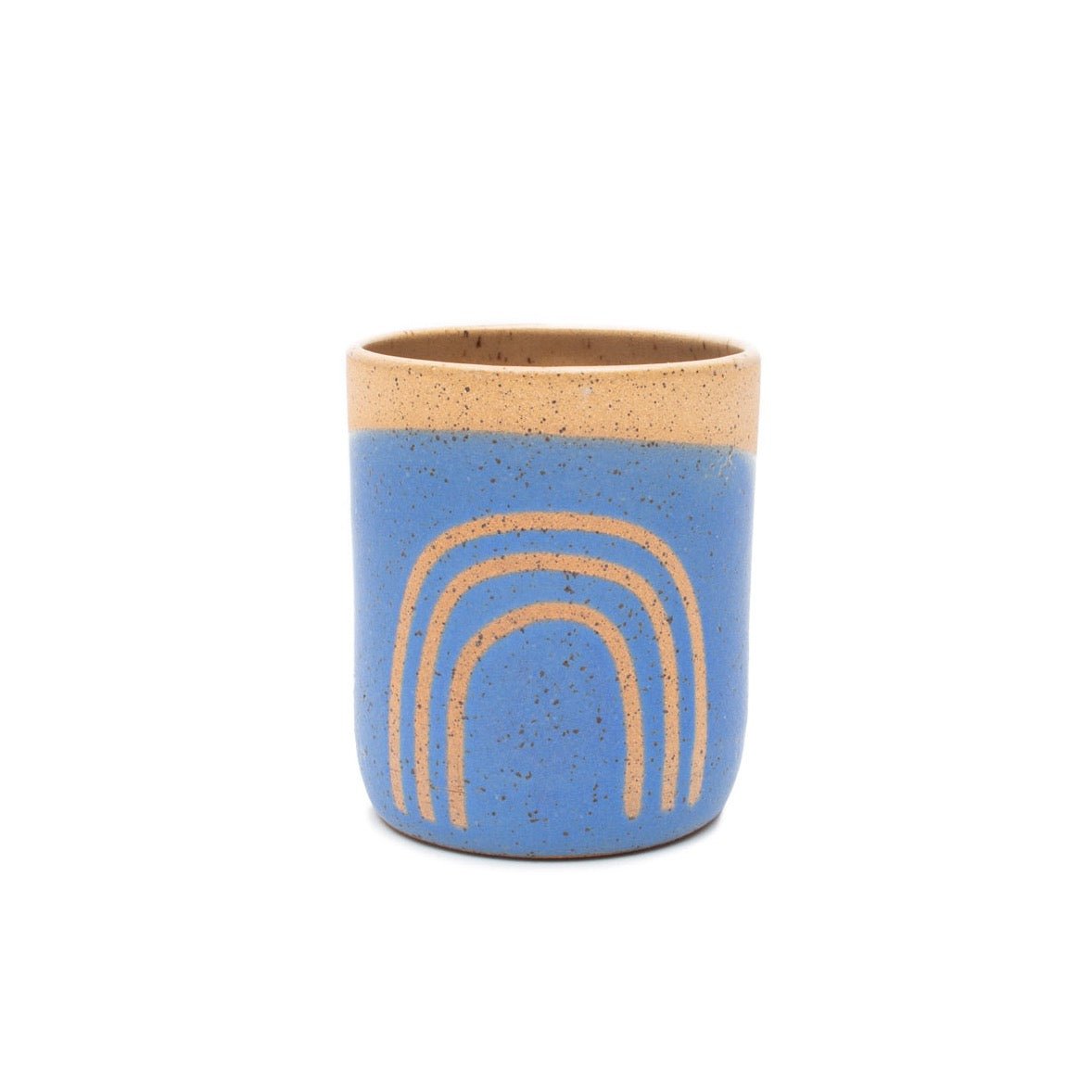 A handless tumbler in matte blue glaze and natural speckled clay rainbow outline. The Tall Tumbler in Cobalt with Rainbow is designed and handmade by Sunflower Studio in Portland, OR.