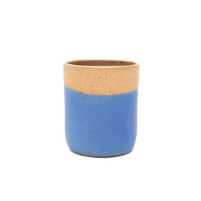 The back side of a handless tumbler in matte blue glaze and natural speckled clay rainbow outline. The Tall Tumbler in Cobalt with Rainbow is designed and handmade by Sunflower Studio in Portland, OR.