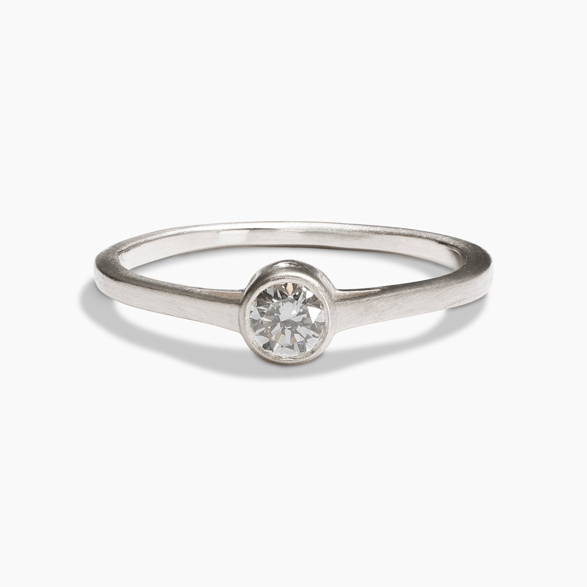 Sano ring from Betsy & Iya in a 14K recycled white gold band with two accent diamonds inset on the side and a central round brilliant cut lab-grown diamond (0.25 ct).