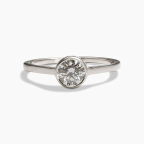 Sano ring from Betsy & Iya in a 14K recycled white gold band with two accent diamonds inset on the side and a central round brilliant cut lab-grown diamond (0.6 ct).