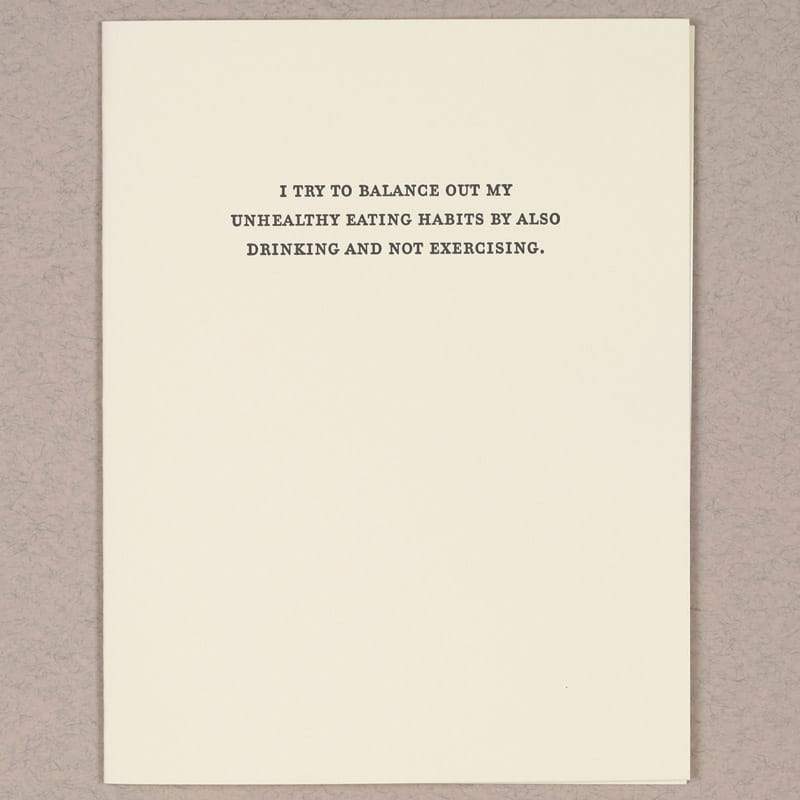 Kraft card with black text that reads: "I TRY TO BALANCE OUT MY UNHEALTHY EATING HABITS BY ALSO DRINKING AND NOT EXERCISING." Designed and made by Sapling Press in Pittsburgh, PA.
