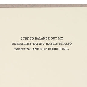 Kraft card with black text that reads: "I TRY TO BALANCE OUT MY UNHEALTHY EATING HABITS BY ALSO DRINKING AND NOT EXERCISING." Designed and made by Sapling Press in  Pittsburgh, PA.