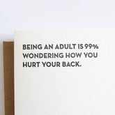 Kraft card with black text that reads: "BEING AN ADULT IS 99% WONDERING HOW YOU HURT YOUR BACK." Designed and made by Sapling Press in Pittsburgh, PA.