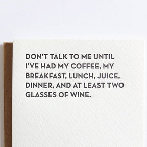 Black text on a Kraft card reads: " DON'T TALK TO ME UNTIL I'VE HAD MY COFFEE, MY BREAKFAST, LUNCH, JUICE, DINNER AND AT LEAST TWO GLASSES OF WINE." Designed by Sapling press and printed in Pittsburgh, PA.