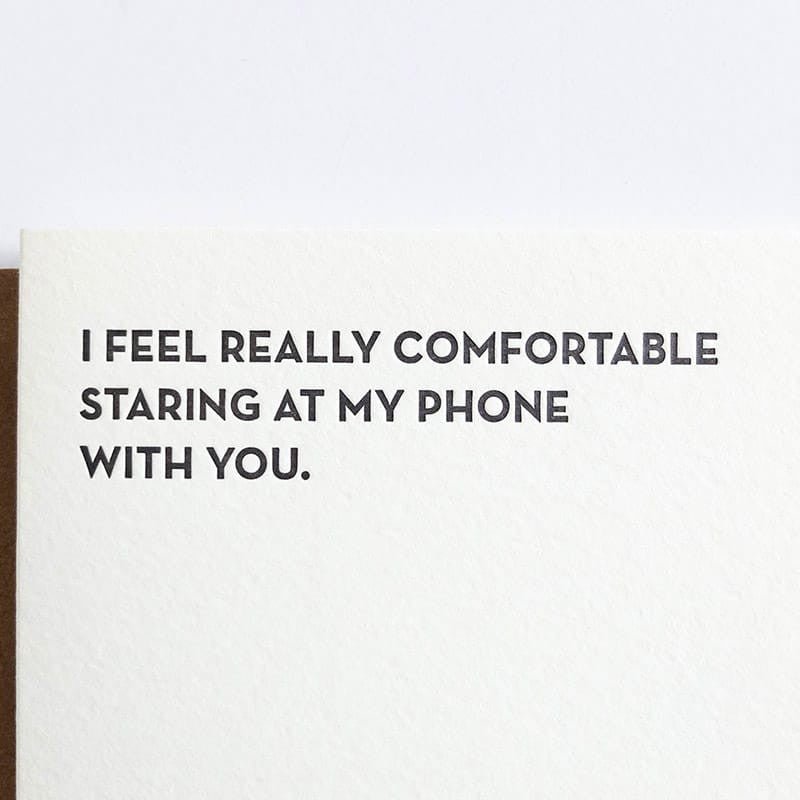 Kraft card with black text that reads: "I FEEL REALLY COMFORTABLE STARING AT MY PHONE WITH YOU." Designed by Sapling Press and printed in Pittsburgh, PA.
