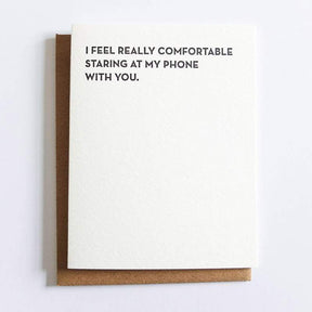 Kraft card with black text that reads: "I FEEL REALLY COMFORTABLE STARING AT MY PHONE WITH YOU." Comes with a brown Kraft envelope. Designed by Sapling Press and printed in Pittsburgh, PA.