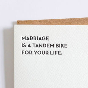 Kraft card with black text that reads: "MARRIAGE IS A TANDEM BIKE FOR YOUR LIFE." Comes with a brown Kraft envelope. Designed by Sapling Press and printed in Pittsburgh, PA.