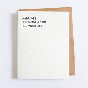 Kraft card with black text that reads: "MARRIAGE IS A TANDEM BIKE FOR YOUR LIFE." Comes with a brown Kraft envelope. Designed by Sapling Press and printed in Pittsburgh, PA.