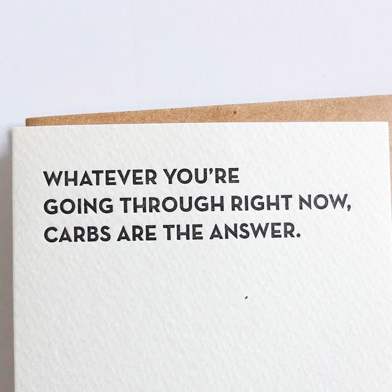 Kraft card with black text that reads: "WHATEVER YOU'RE GOING THROUGH RIGHT NOW, CARBS ARE THE ANSWER." Designed and made by Sapling Press in Pittsburgh, PA.