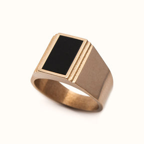 A wide band signet ring with a rectangle of Oregon Black Jasper Inlay flanked by a stair step cut out design. Made in bronze. Designed and handcrafted in Portland, Oregon.