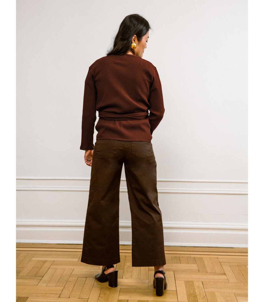 A model wears a high waisted wide leg cropped jean in a dark brown. The Simone Jean in Brown is designed by Loup and made in New York City, USA.