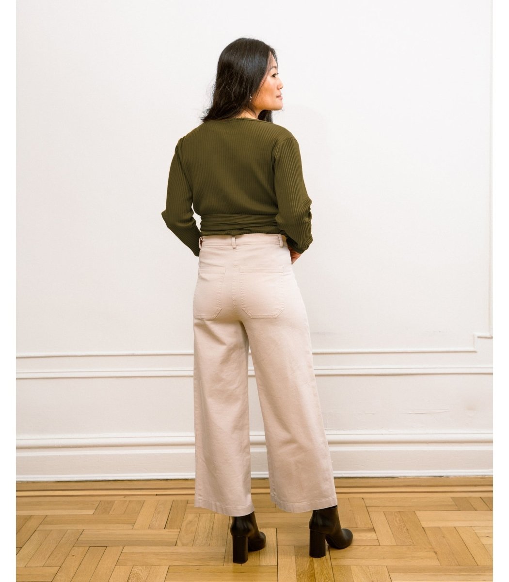 A model wears a high waisted wide leg cropped jean in an off-white color. The Simone Jean in Sand is designed by Loup and made in New York City, USA.