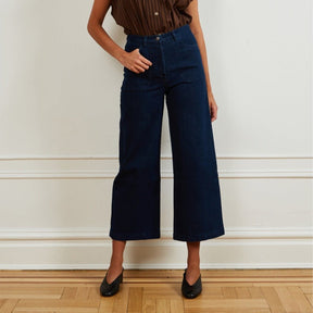 A model wears a high waisted wide leg cropped jean in a dark blue denim. The Simone Jean in Dark Indigo is designed by Loup and made in New York City, USA.