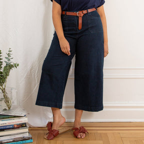  A model wears a high waisted wide leg cropped jean in a dark blue denim. The Simone Jean in Dark Indigo is designed by Loup and made in New York City, USA.