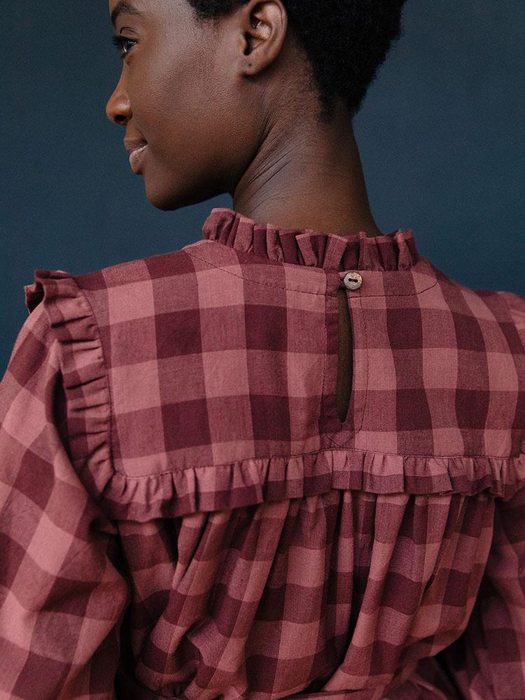 Model shows back detail of the Soleil Long Sleeve Dress in Plum Gingham. Designed by Mata Traders and made in Nepal.