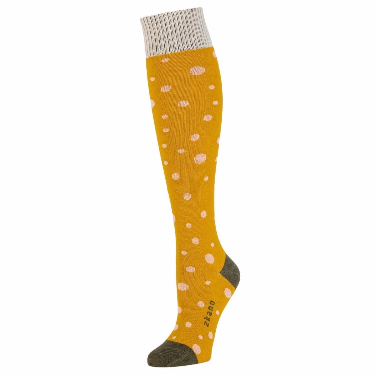 Yellow knee sock with pale pink polka dot pattern and white ribbed collar. Heel and toe are an army green as well as the logo along the arch. The Stella Sock in Harvest Gold is from Zkano and made in Alabama, USA.