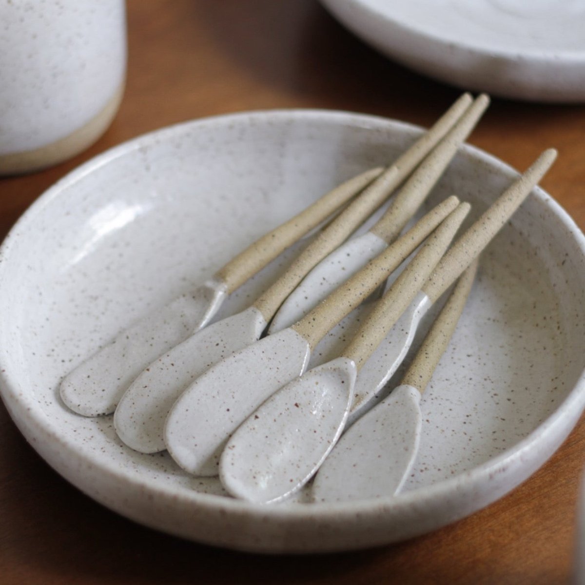 Multiple stirring spoons made with stoneware clay with a glossy white speckled finish. Designed and hand built by Amy A Ceramics in Portland, Oregon.