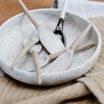 Multiple stirring spoons made with stoneware clay with a glossy white speckled finish. Designed and hand built by Amy A Ceramics in Portland, Oregon.