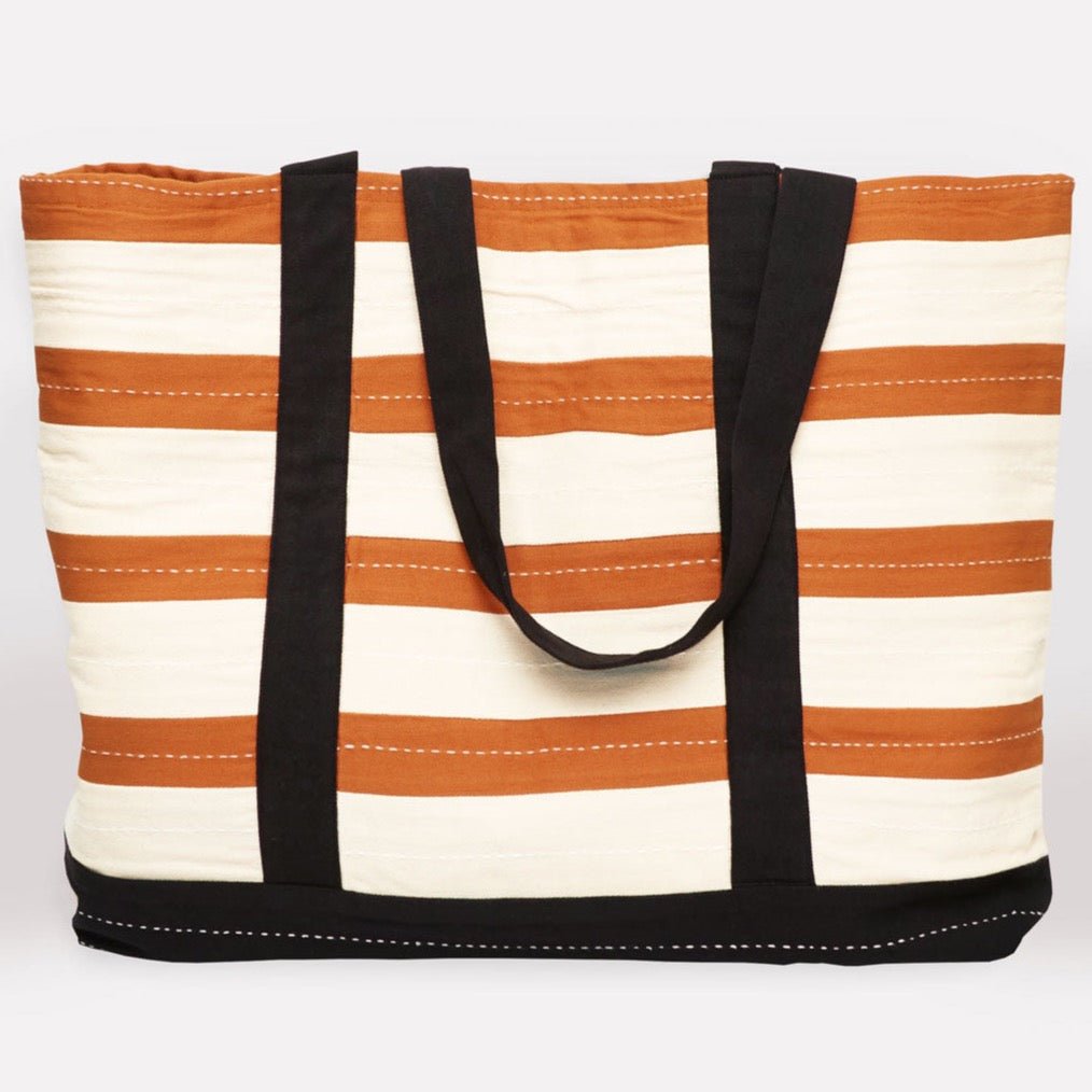 Orange and cream striped tote bag with black straps and white stitching. The Striped Canvas Tote Bag in Camel is designed by Anchal in Louisville, Kentucky and handmade in Ajmer, India.