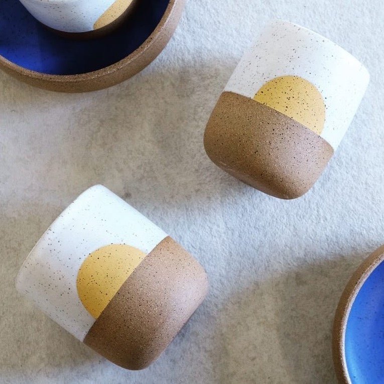 Speckled stoneware handless mug with a white satin glaze collar and yellow concentric design. Designed and hand thrown by Wolf ceramics in Hood River, Oregon.
