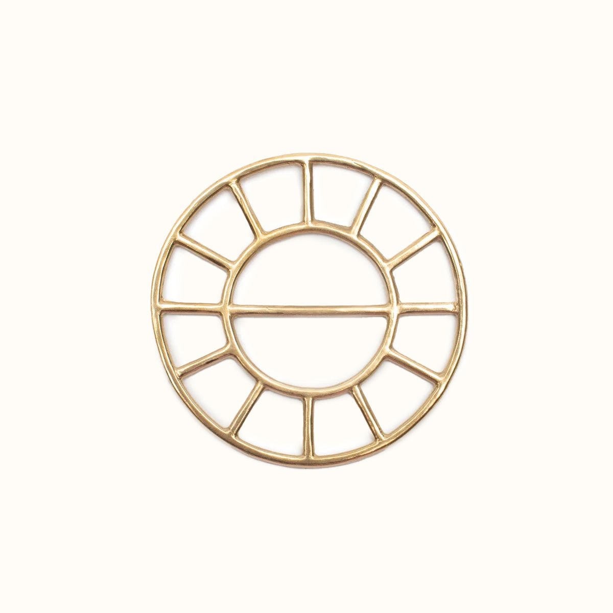 A circular brass scarf bolo. The Scarf Bolo is designed and handmade by Take Shape Studio in Berkeley, California.