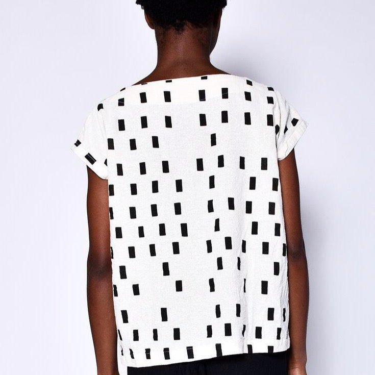 Cream colored short sleeve tunic with black square pattern. Designed and sewn by UZI in Brooklyn, New York.  Edit alt text